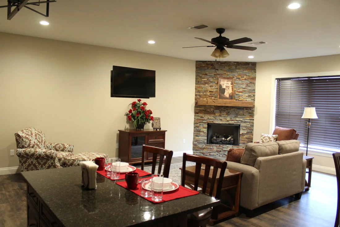 Vianney Villa apartment living room with fireplace, kitchen island, and dining table